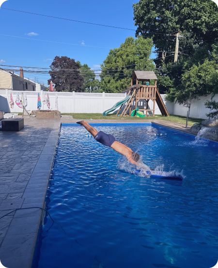 a boy jumps into the pool